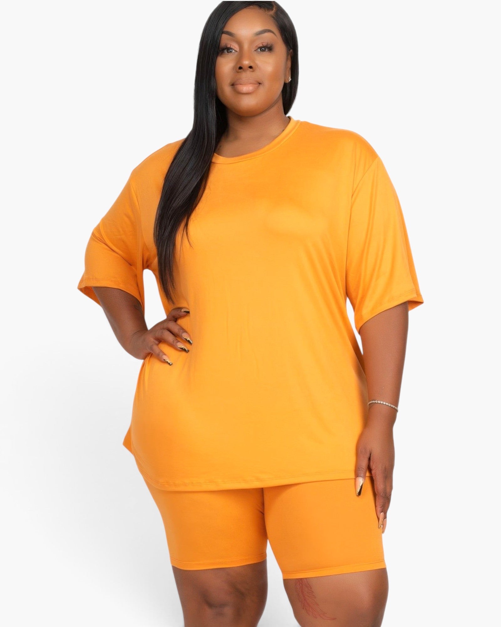 Beach Rose Co. plus size mango orange loose fit top and biker shorts set worn by a model on a white background.
