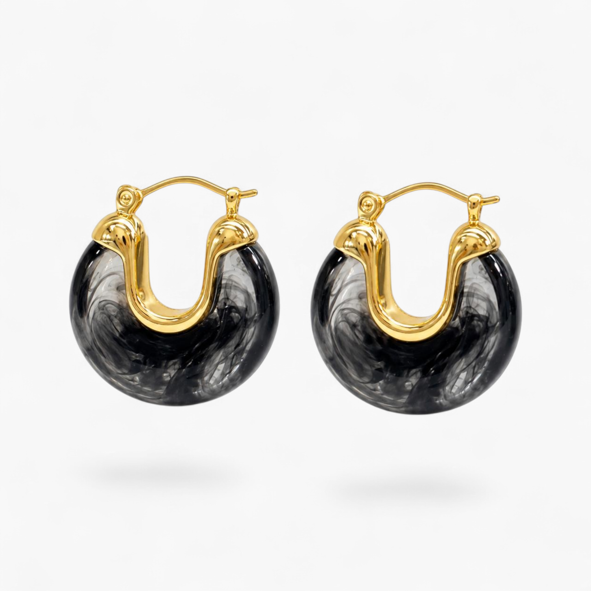 Beach Rose Co. 18K gold filled hoop earrings featuring black and white marbled resin with a hinged closure.