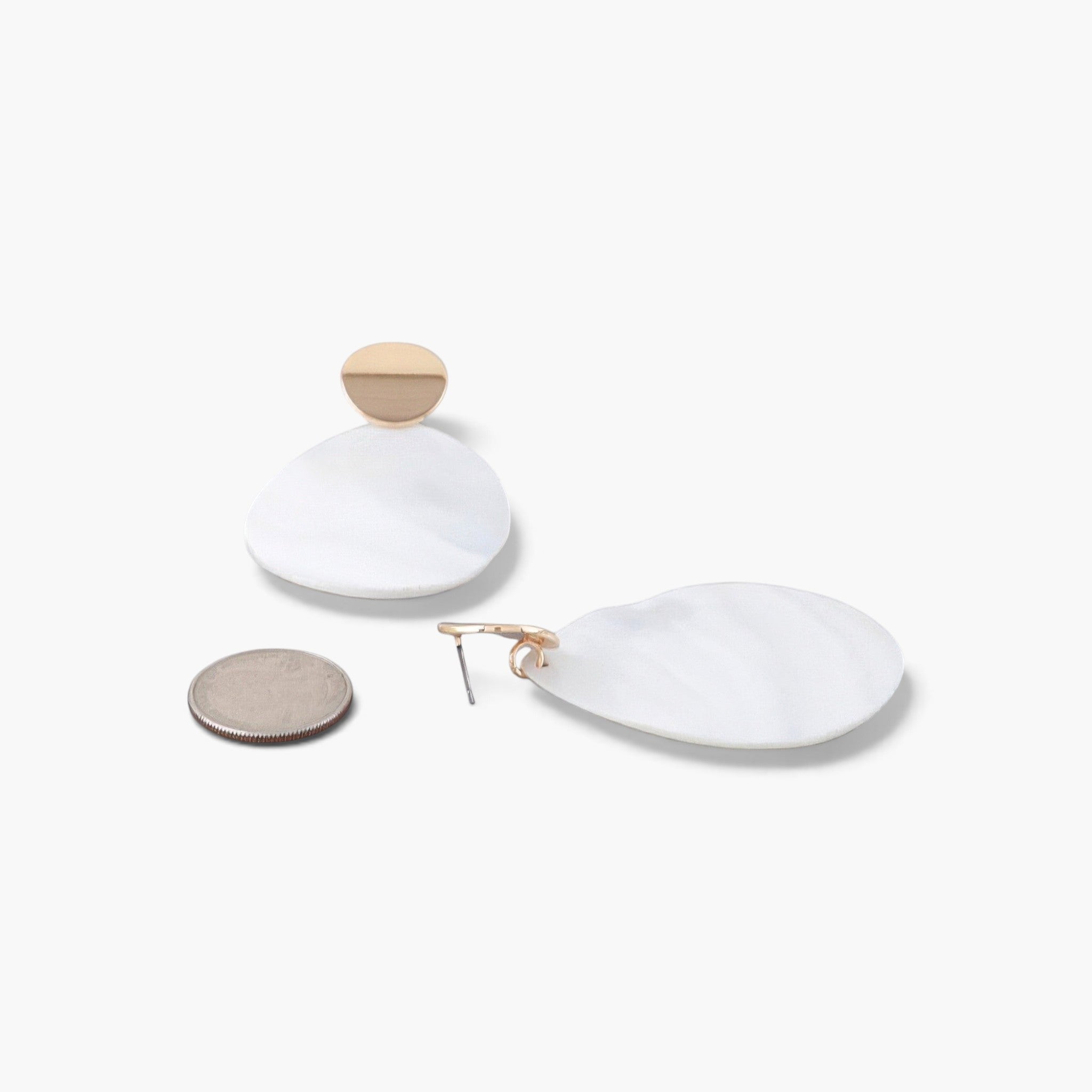 Beach Rose Co. oval earrings featuring cream marbled stones set in polished gold frames on a white background.
