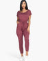 Beach Rose Co. woman wearing a mauve two-way shoulder drawstring jumpsuit in soft stretch jersey with tapered legs.