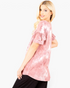 Beach Rose Co. mauve tie-dye top with layered ruffle sleeves worn by a blonde model in a side profile view.