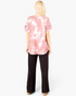 Beach Rose Co. mauve tie-dye top with layered ruffle sleeves and a curved hem, worn by a blonde model from behind.