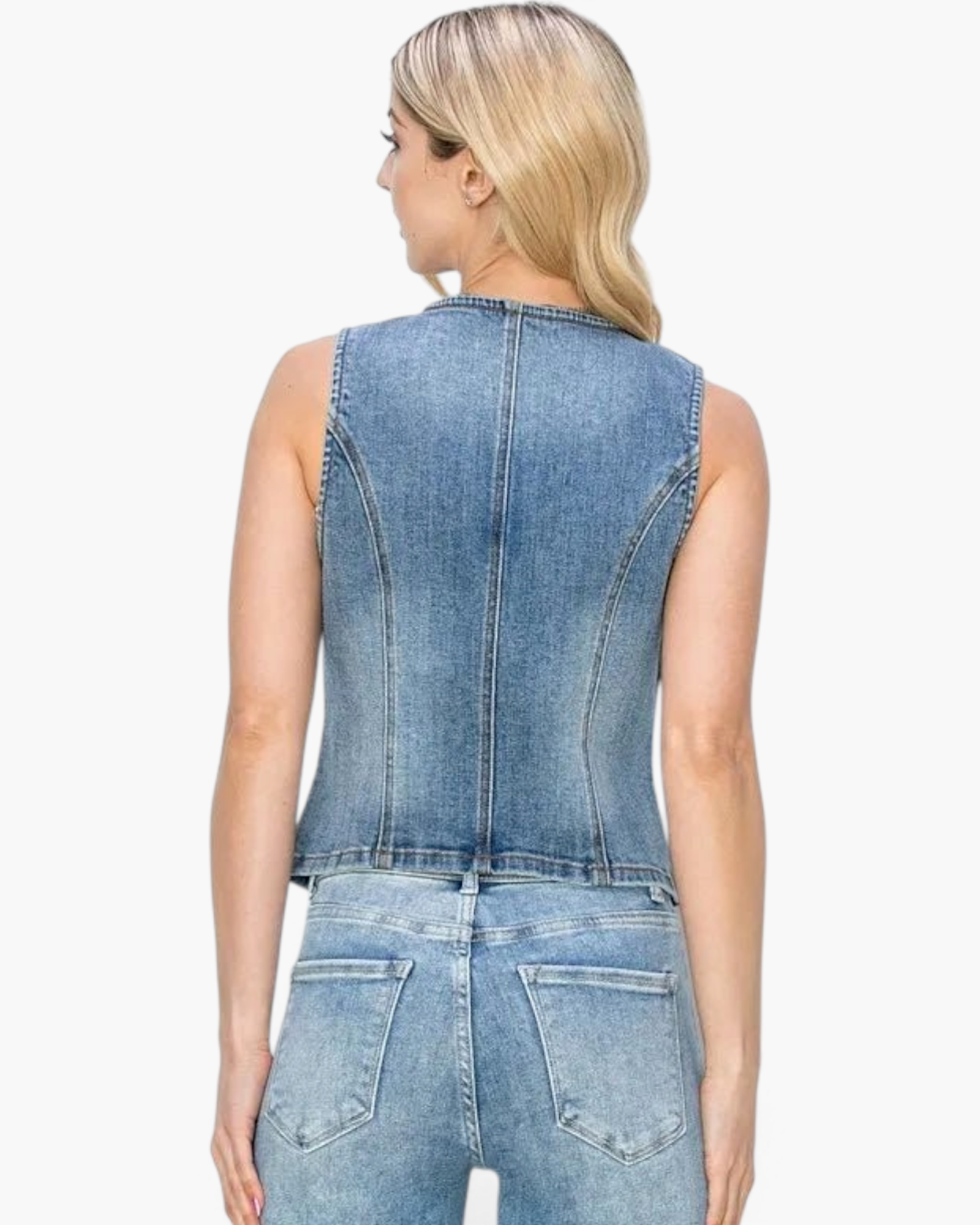 Back view of a blonde model wearing a Beach Rose Co. medium wash stretch denim vest with contouring seams.