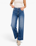 Beach Rose Co. medium wash high-rise wide-leg denim jeans with seamed cuffs and raw hems on a model