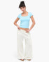 Model wearing Beach Rose Co. mineral wash wide leg cargo pants with raw edge pockets and a light blue crop top
