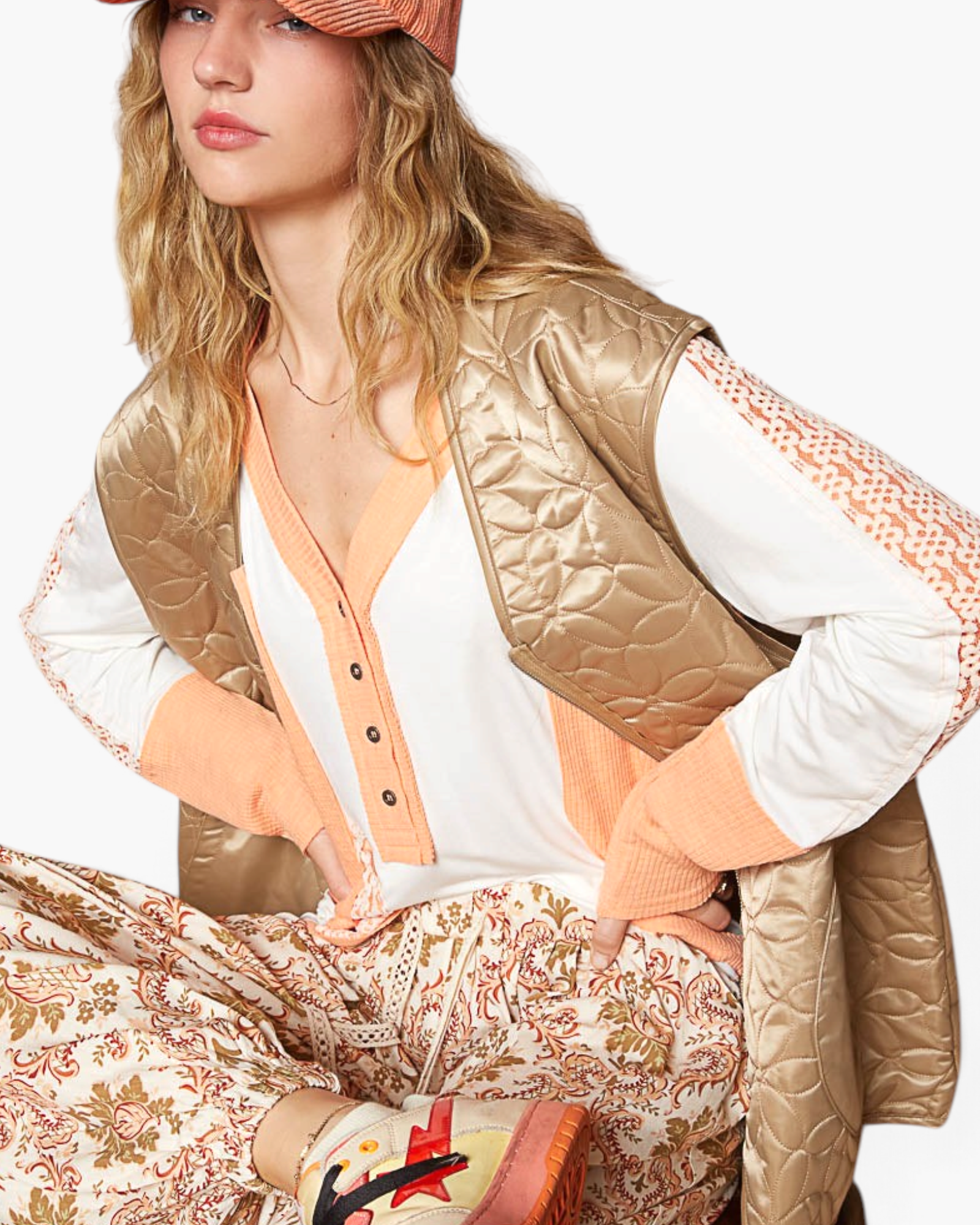 Beach Rose Co. mocha floral quilted zip-up vest worn over a white and peach long-sleeve top with patterned pants.