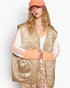 Beach Rose Co. mocha floral quilted zip-up vest with oversized patch pockets worn over a long-sleeve top and cap.