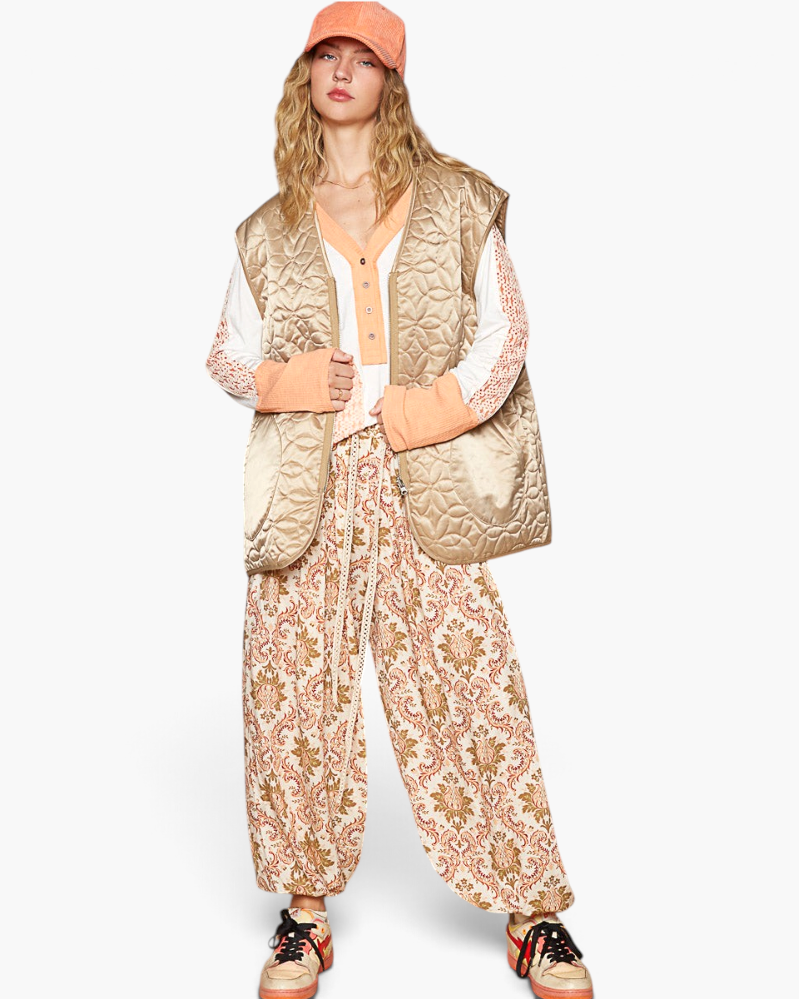 Beach Rose Co. mocha floral quilted nylon zip-up vest worn by a model with patterned pants and a peach baseball cap.