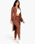 Model wearing a Beach Rose Co. mocha brown ribbed long cardigan and matching leggings set with a white crop top