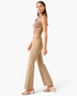 Model wearing Beach Rose Co. mocha high-rise flare pants with a crossover V-waist and stretch fabric, side view.