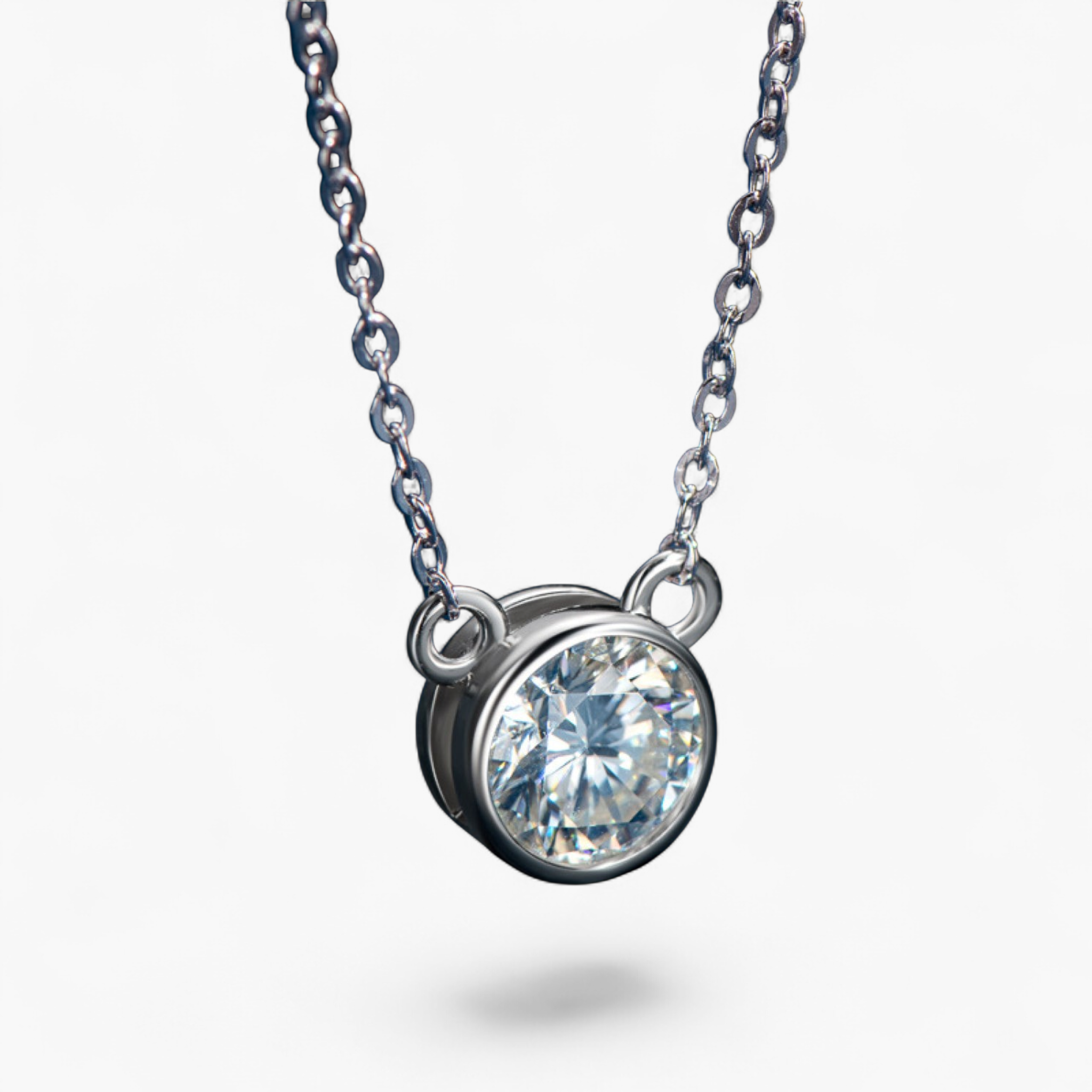Beach Rose Co. 1 carat round moissanite solitaire necklace in a silver bezel setting on a delicate link chain.