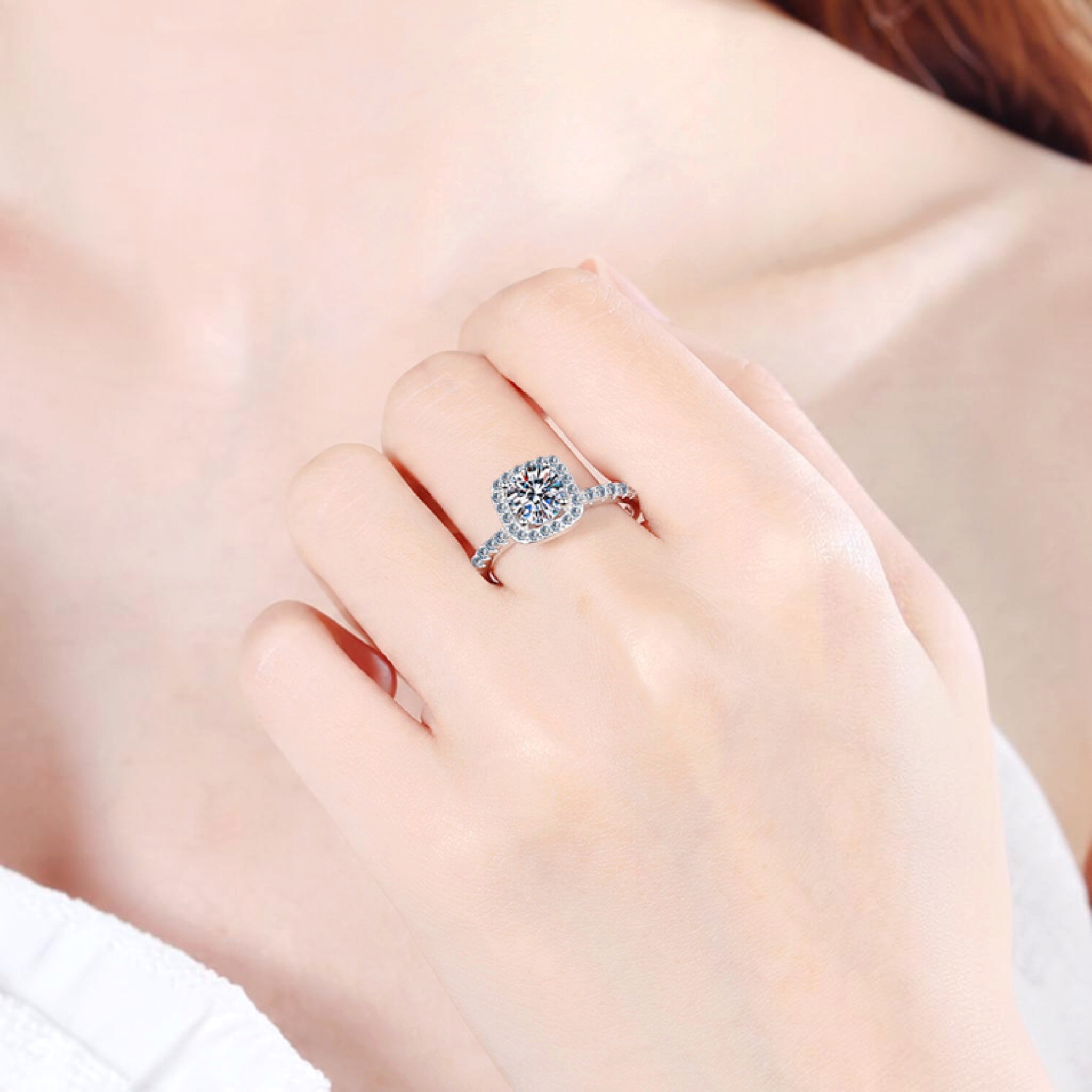 Beach Rose Co. 1 carat round moissanite ring with a square halo and zircon accents set in rhodium-plated silver.