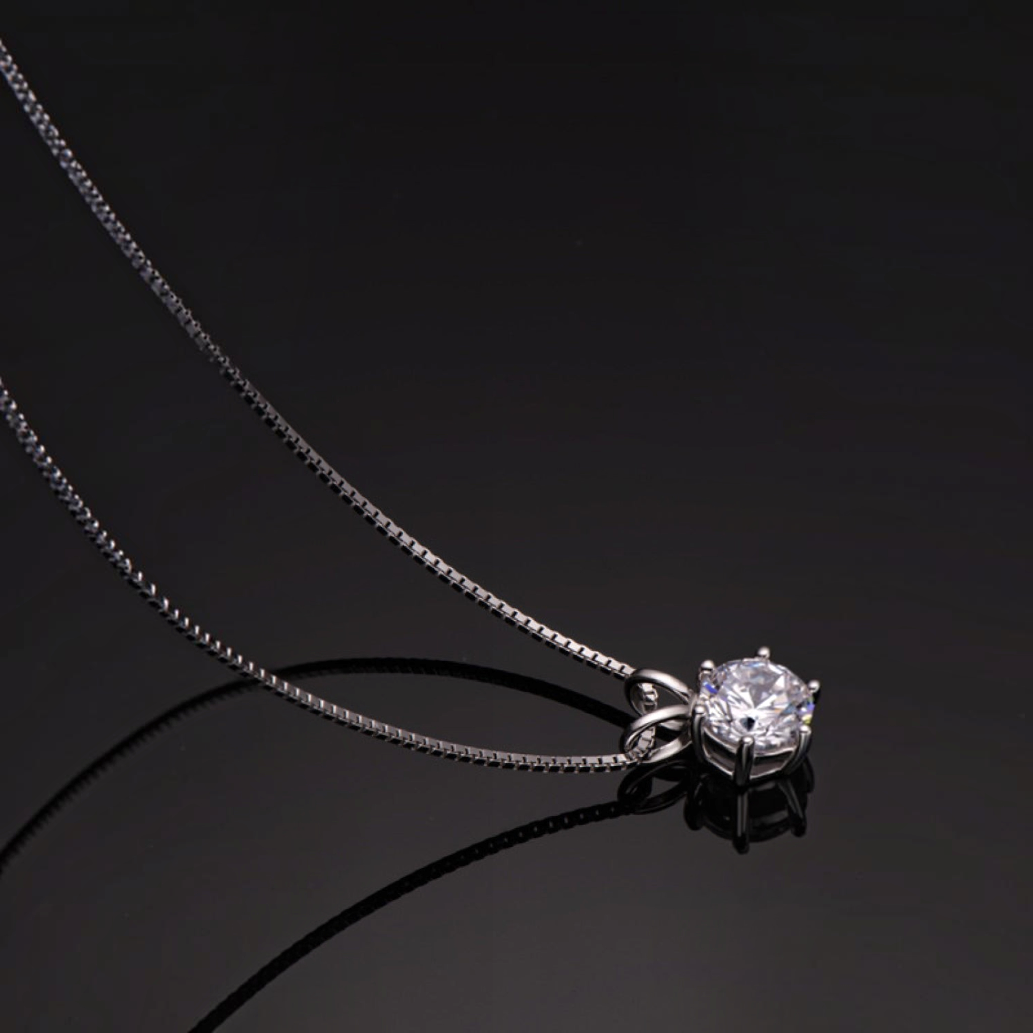 Beach Rose Co. 1 carat round moissanite solitaire pendant necklace in sterling silver with a delicate box chain.