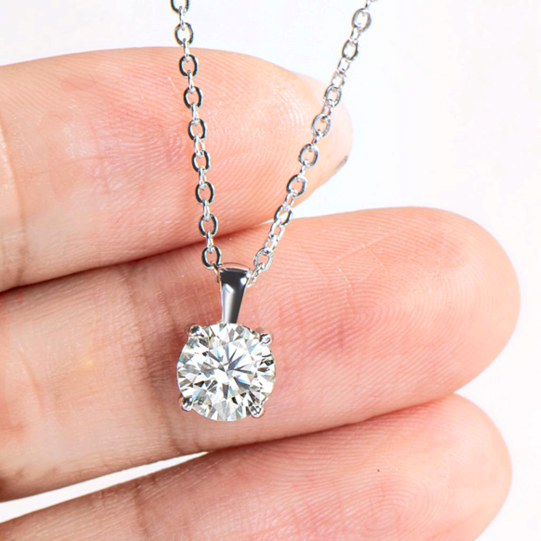 Beach Rose Co. 1 carat round moissanite solitaire pendant necklace in sterling silver with a four-prong setting.