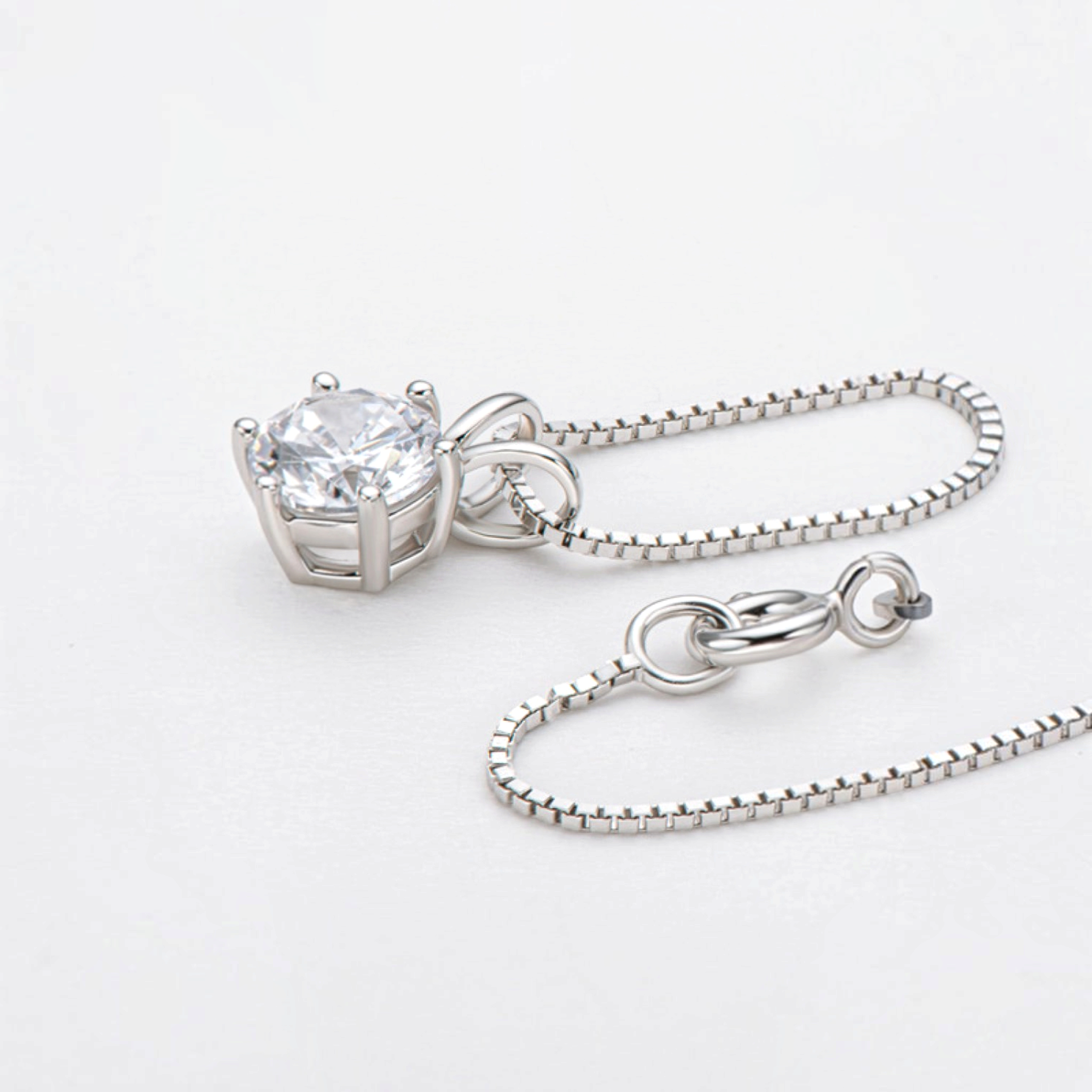 Beach Rose Co. 1 carat round moissanite solitaire pendant necklace in sterling silver with a delicate box chain.