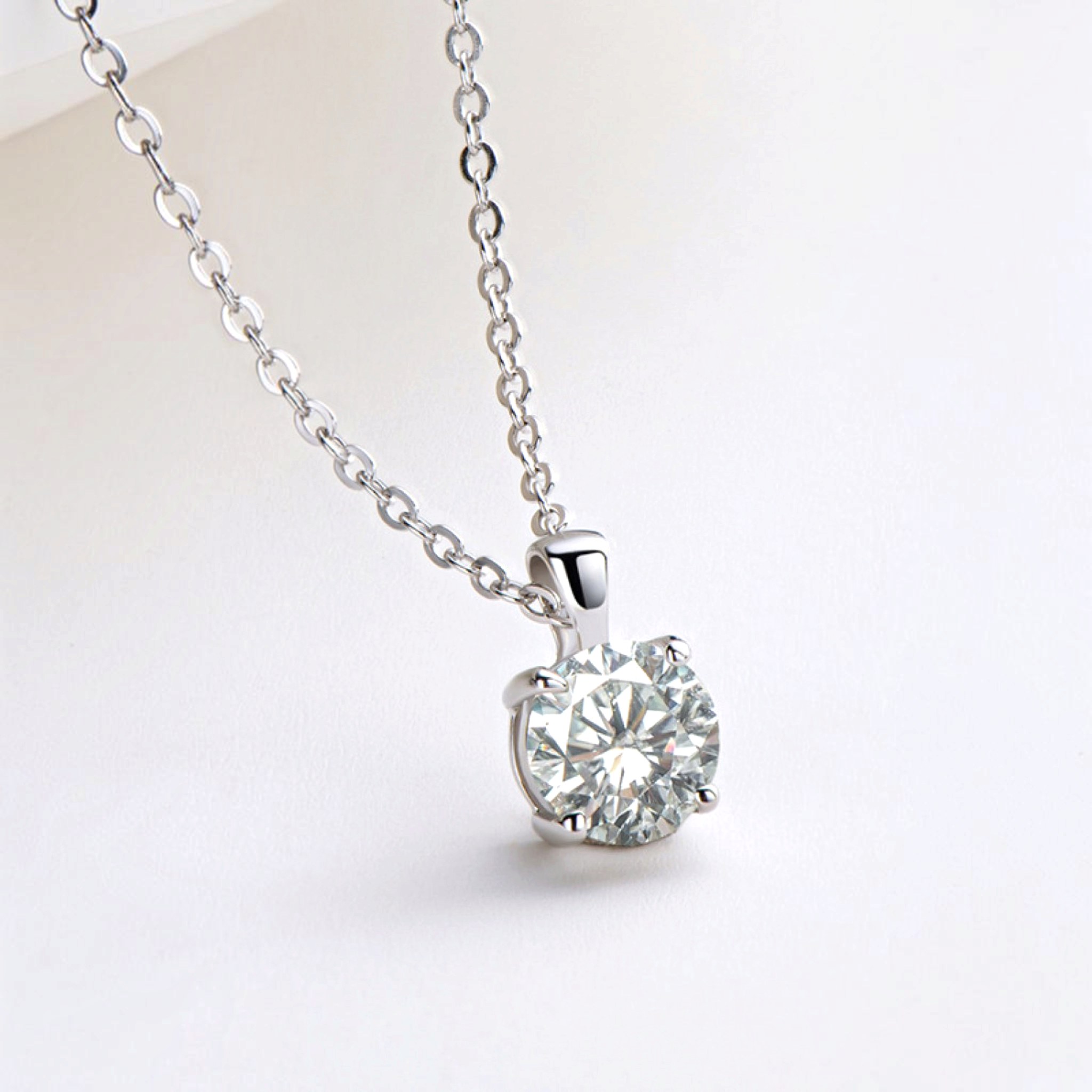 Beach Rose Co. 1 carat round moissanite solitaire pendant necklace in sterling silver with a delicate link chain.
