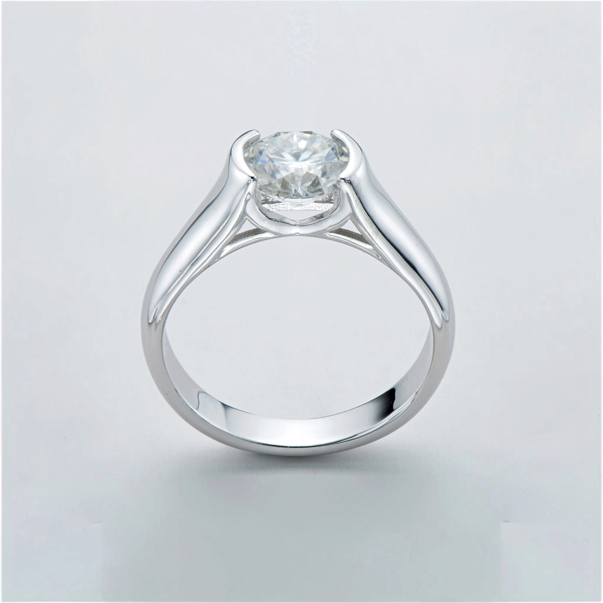 Beach Rose Co. 2 carat round moissanite solitaire ring in platinum-plated sterling silver with a half-bezel setting.