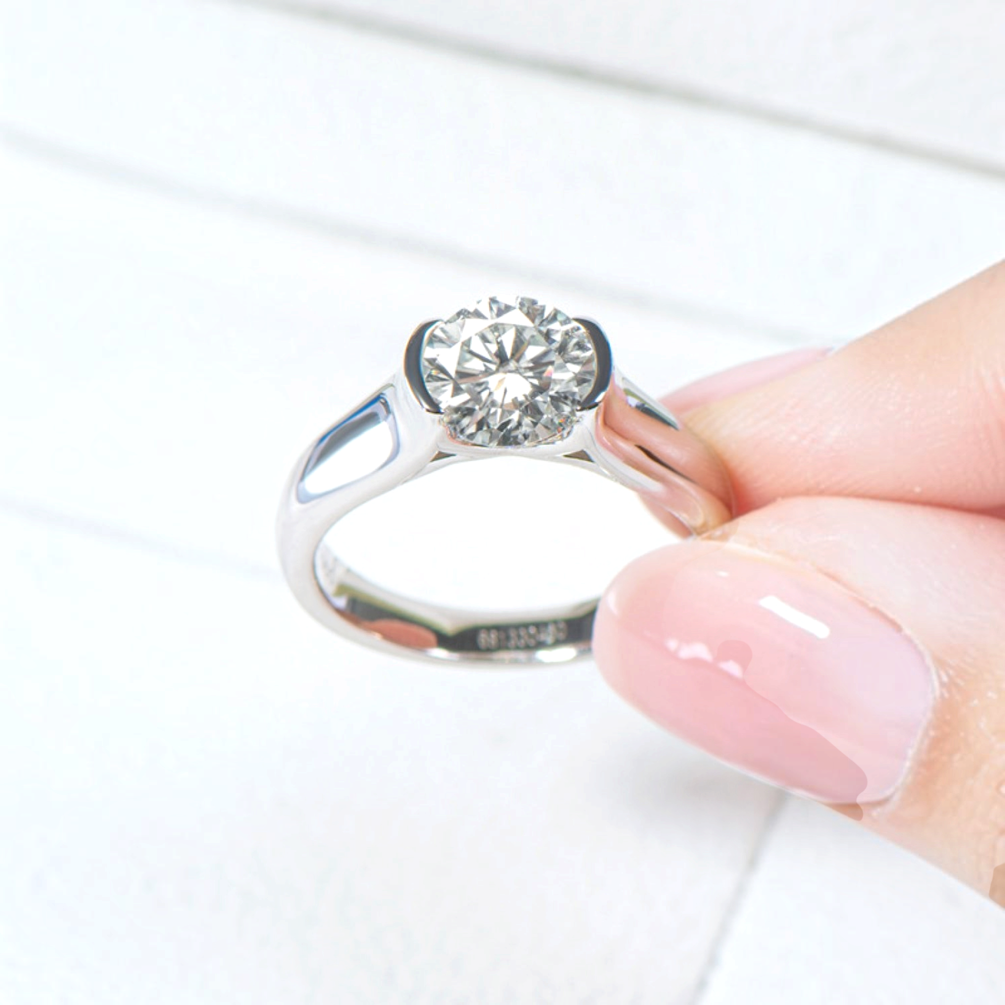 Beach Rose Co. 2 carat round moissanite solitaire ring in platinum-plated sterling silver with a half-bezel setting.