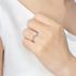 Beach Rose Co. 1 carat round moissanite solitaire ring in platinum-plated sterling silver on a woman's hand.