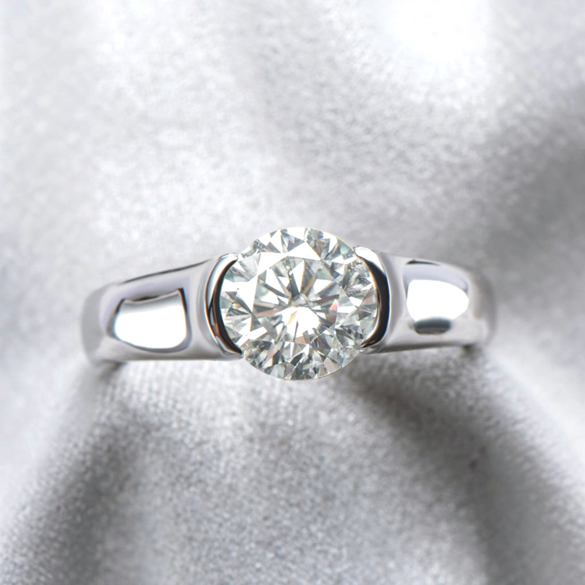 Beach Rose Co. 2 carat round moissanite solitaire ring in platinum-plated sterling silver with a half-bezel setting.