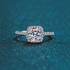 Beach Rose Co. 1 carat round moissanite ring with a square halo and zircon accents in rhodium-plated sterling silver.