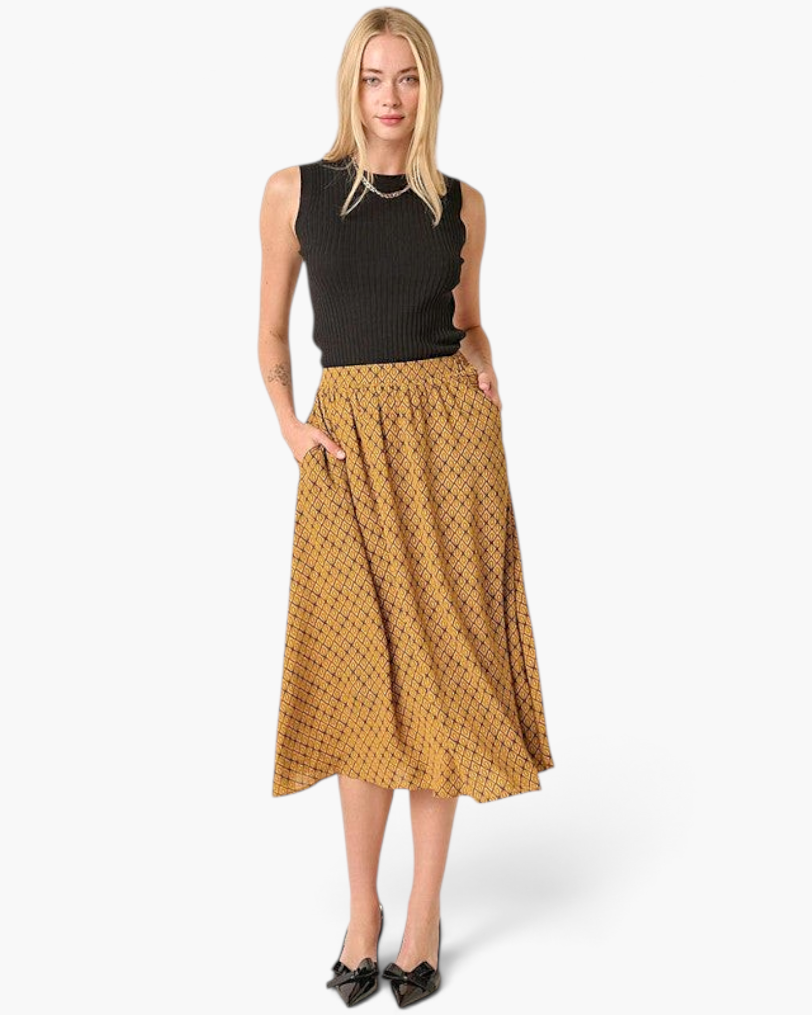 Beach Rose Co. mustard midi skirt with geometric print, elastic waistband, and side pockets on a blonde model.