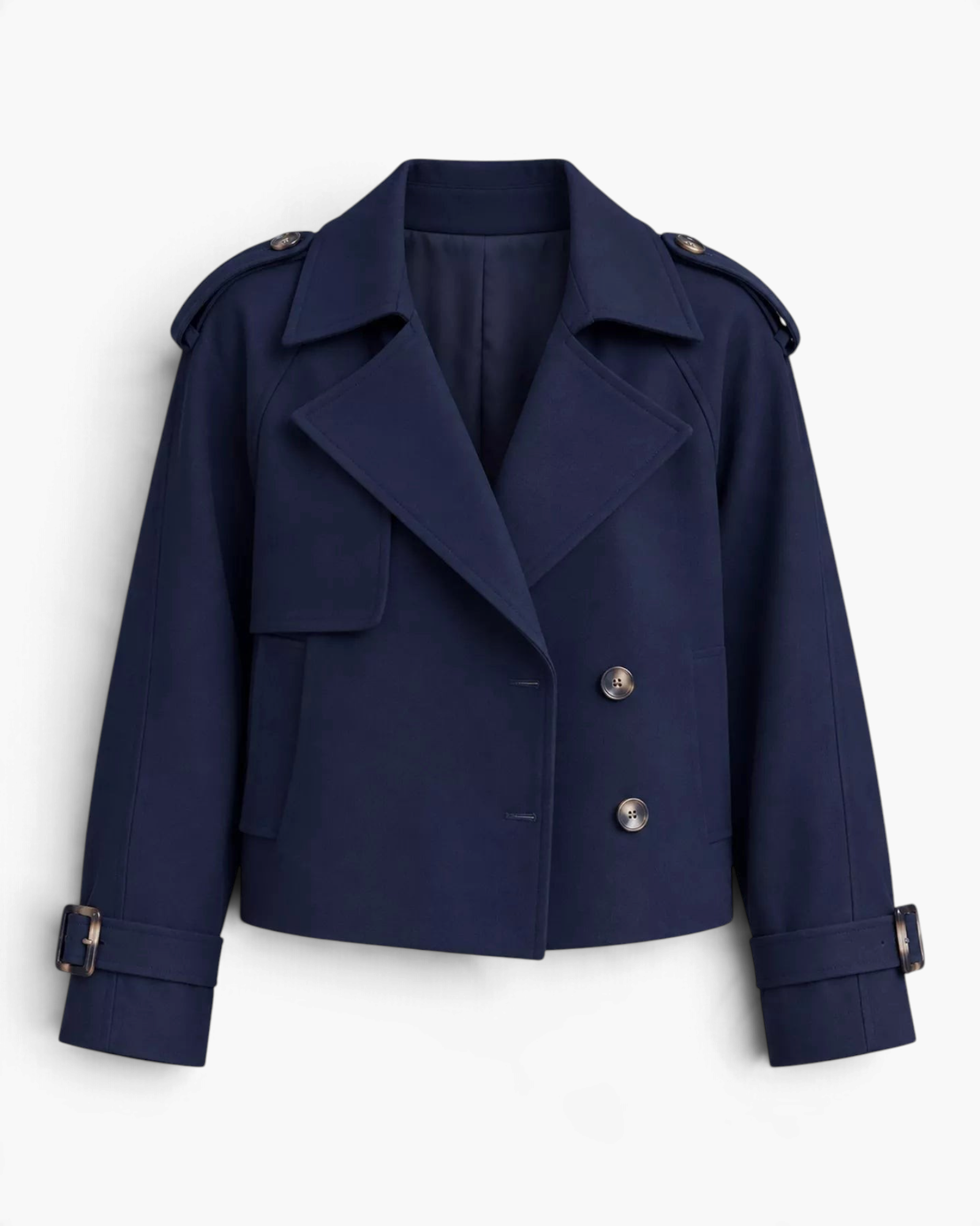 Beach Rose Co. navy blue cropped double-breasted trench jacket with wide lapels, shoulder tabs, and buckled cuffs.