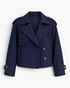 Beach Rose Co. navy blue cropped double-breasted trench jacket with wide lapels, shoulder tabs, and buckled cuffs.