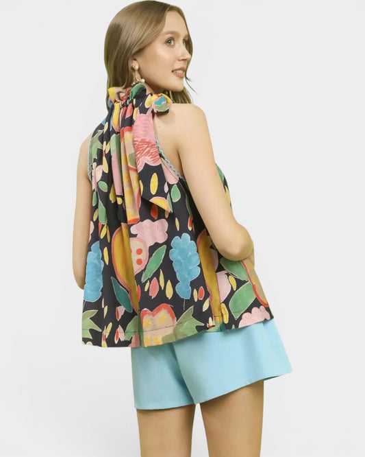 Beach Rose Co. navy halter top with colorful floral print, tie-back neck, and flowy silhouette. Made of rayon/nylon.