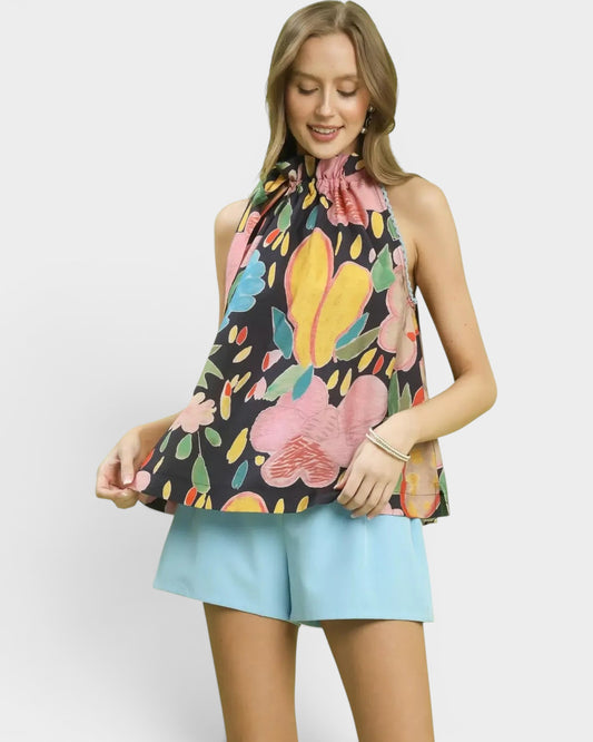 Beach Rose Co. navy halter top with oversized pink, yellow, blue, green, and coral floral print, tie-back detail, and flowy silhouette.