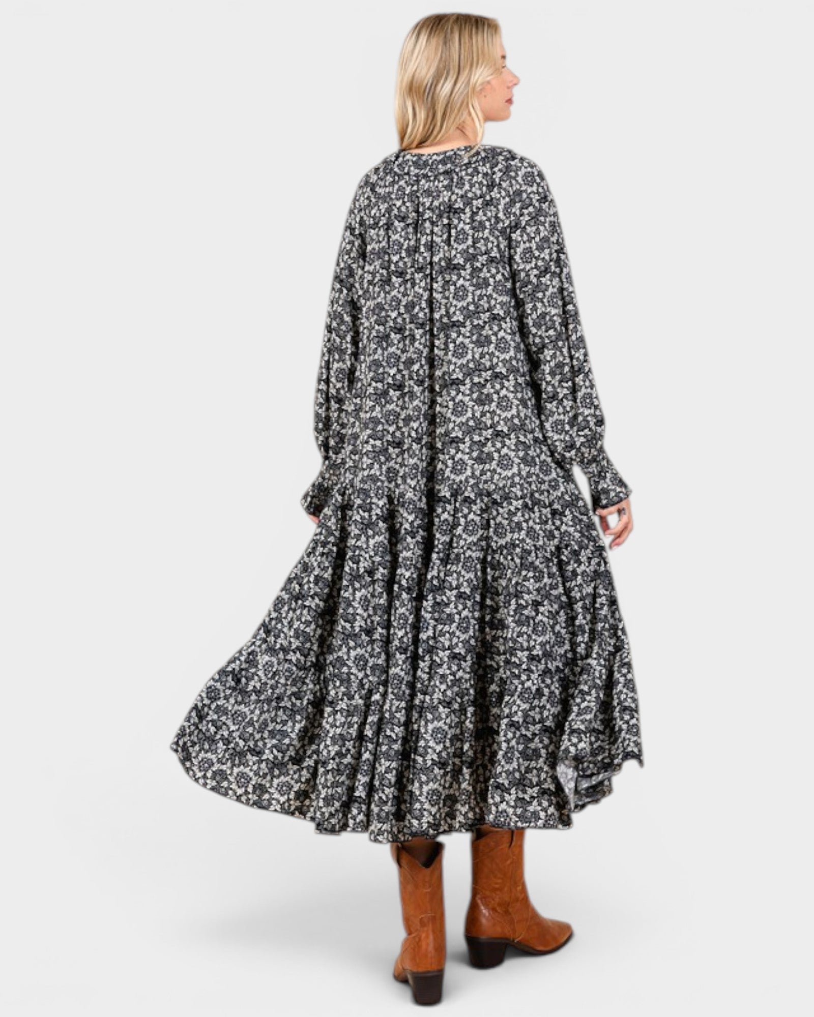 Beach Rose Co. navy floral tiered maxi dress with long sleeves and tie neckline, worn with brown leather boots.
