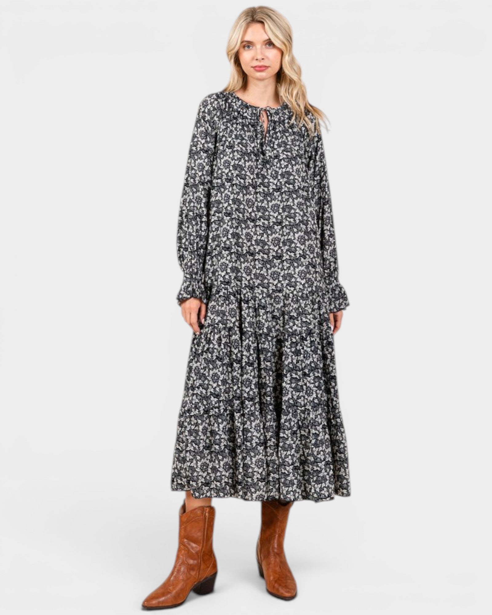 Beach Rose Co. navy floral maxi dress with long sleeves, tie neckline, and tiered skirt, styled with brown boots.