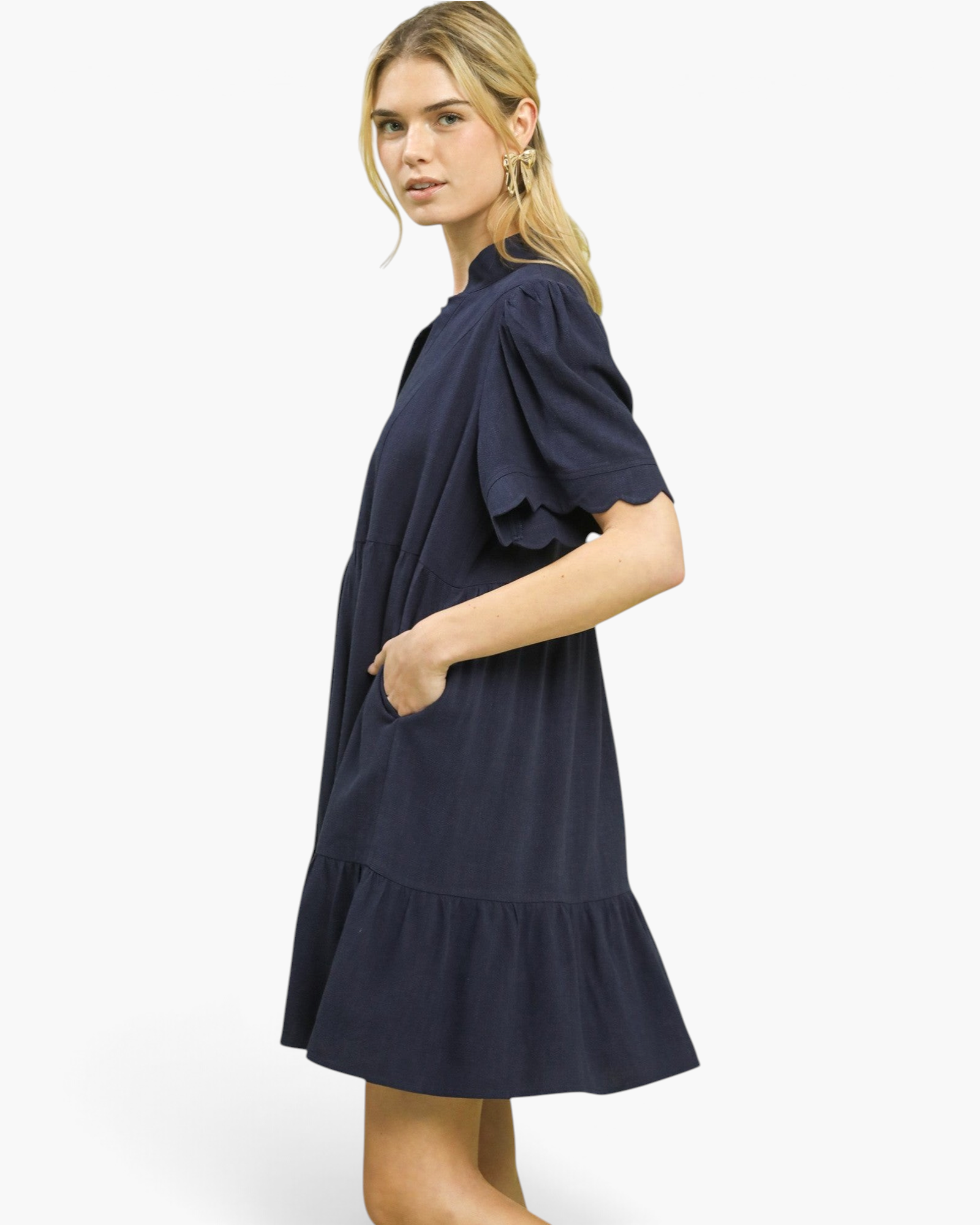 Beach Rose Co. navy linen blend mini dress with scalloped puff sleeves, tiered skirt, and pockets on a blonde model.