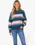 Beach Rose Co. model wearing a navy textured knit sweater with multicolor horizontal stripes and a crew neckline.