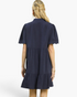 Back view of a Beach Rose Co. navy linen blend mini dress with tiered skirt and scalloped puff sleeves.