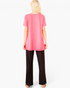 Beach Rose Co. neon pink tunic top with a relaxed A-line silhouette worn by a blonde model from the back view