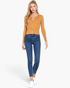 Beach Rose Co. model wearing an ochre ribbed sweater top with a front zipper paired with blue skinny jeans