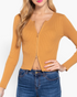 Beach Rose Co. ochre ribbed sweater top with a front zipper, worn with blue jeans on a model.