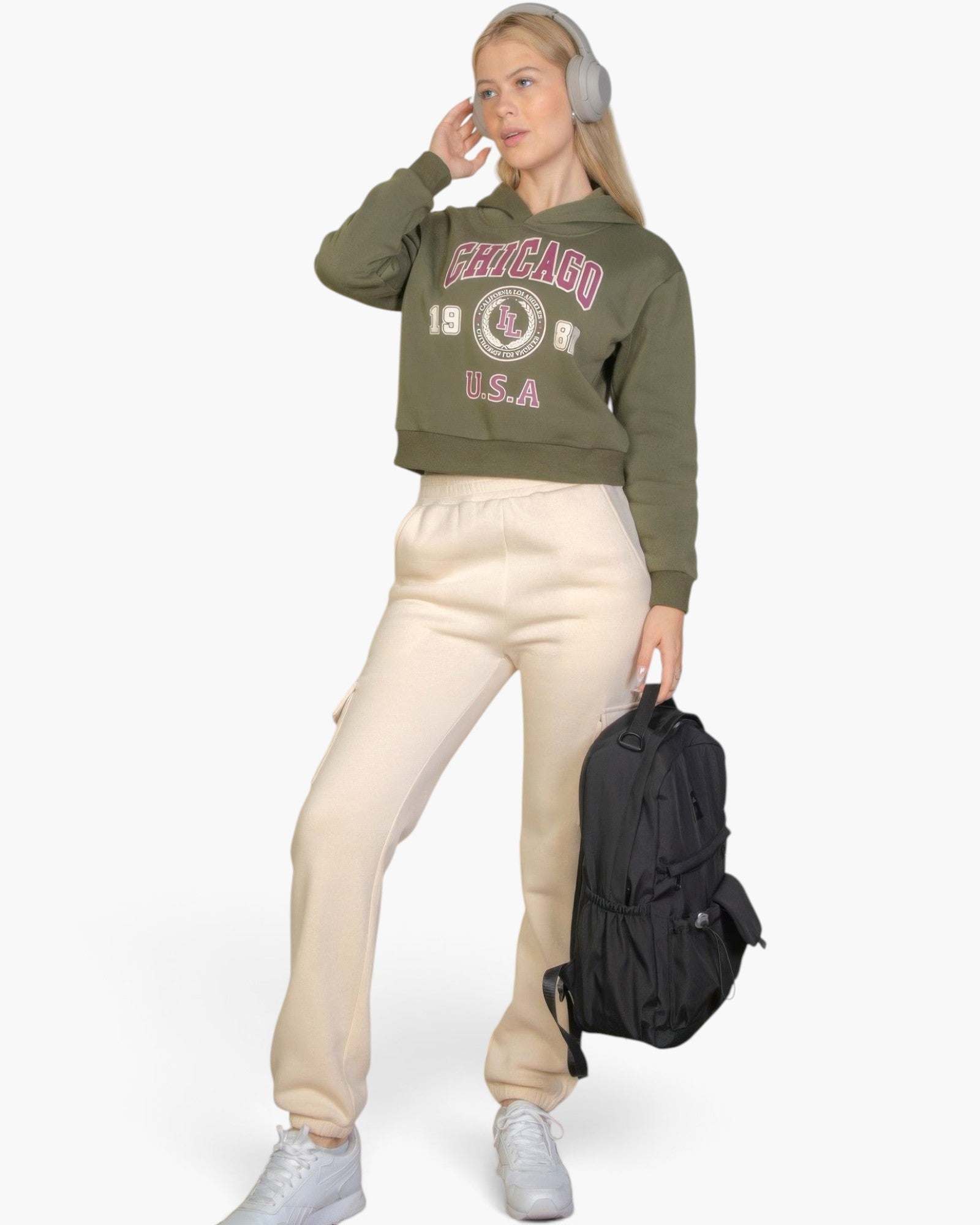 Beach Rose Co. olive green drop shoulder hoodie with Chicago graphic worn by a blonde woman with headphones and backpack