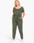 Beach Rose Co. plus size olive green short sleeve jumpsuit with a drawstring waist and pockets on a blonde model