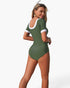 Beach Rose Co. olive green short-sleeve one-piece swimsuit with white contrast trim and a scoop back on a model.