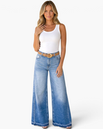 Beach Rose Co. model wearing medium-wash wide-leg jeans with a faded ombre effect, high-rise waist, and raw-edge hem.