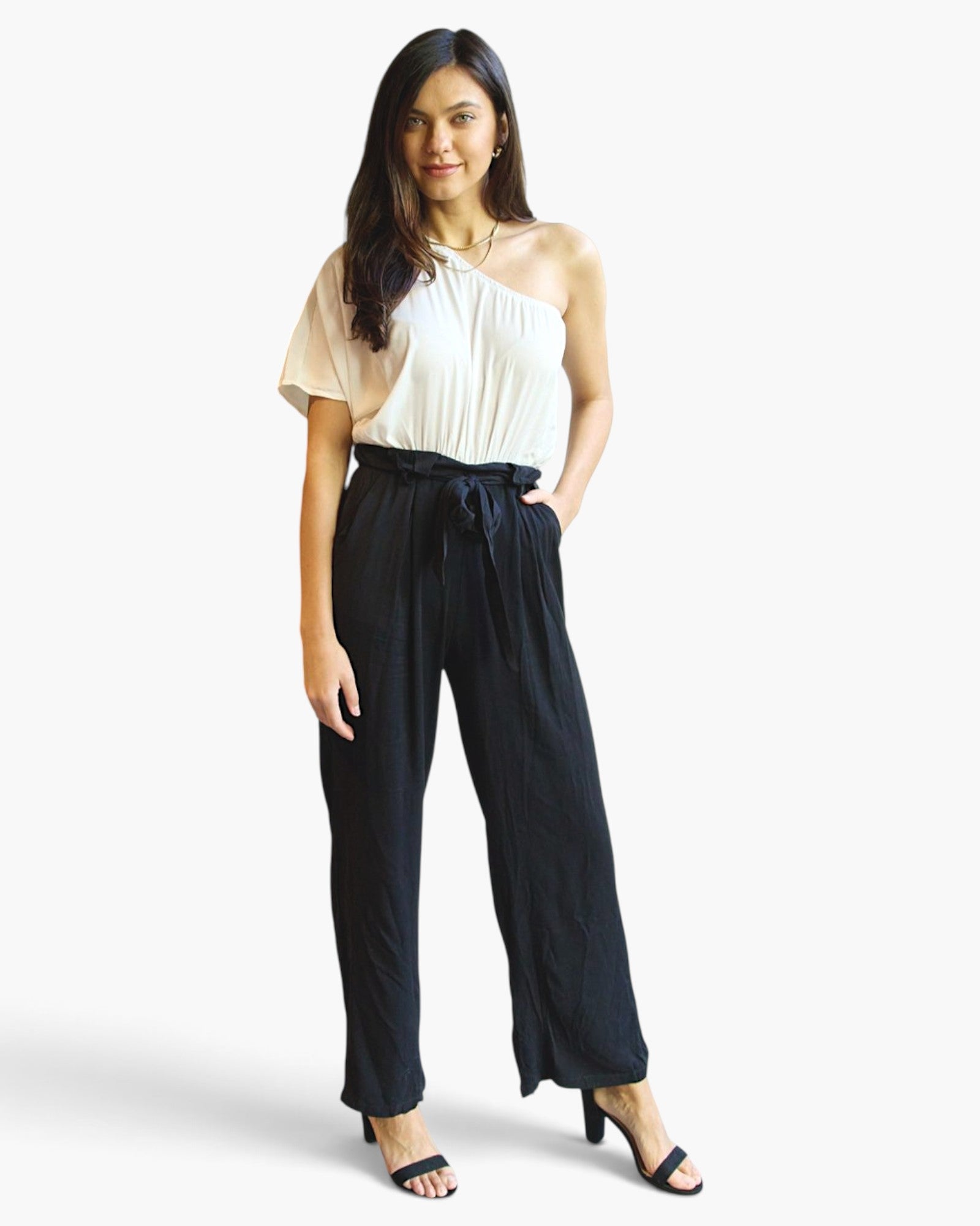 Beach Rose Co. white and black one-shoulder jumpsuit with wide-leg pants, paperbag waist, and self-tie belt on model