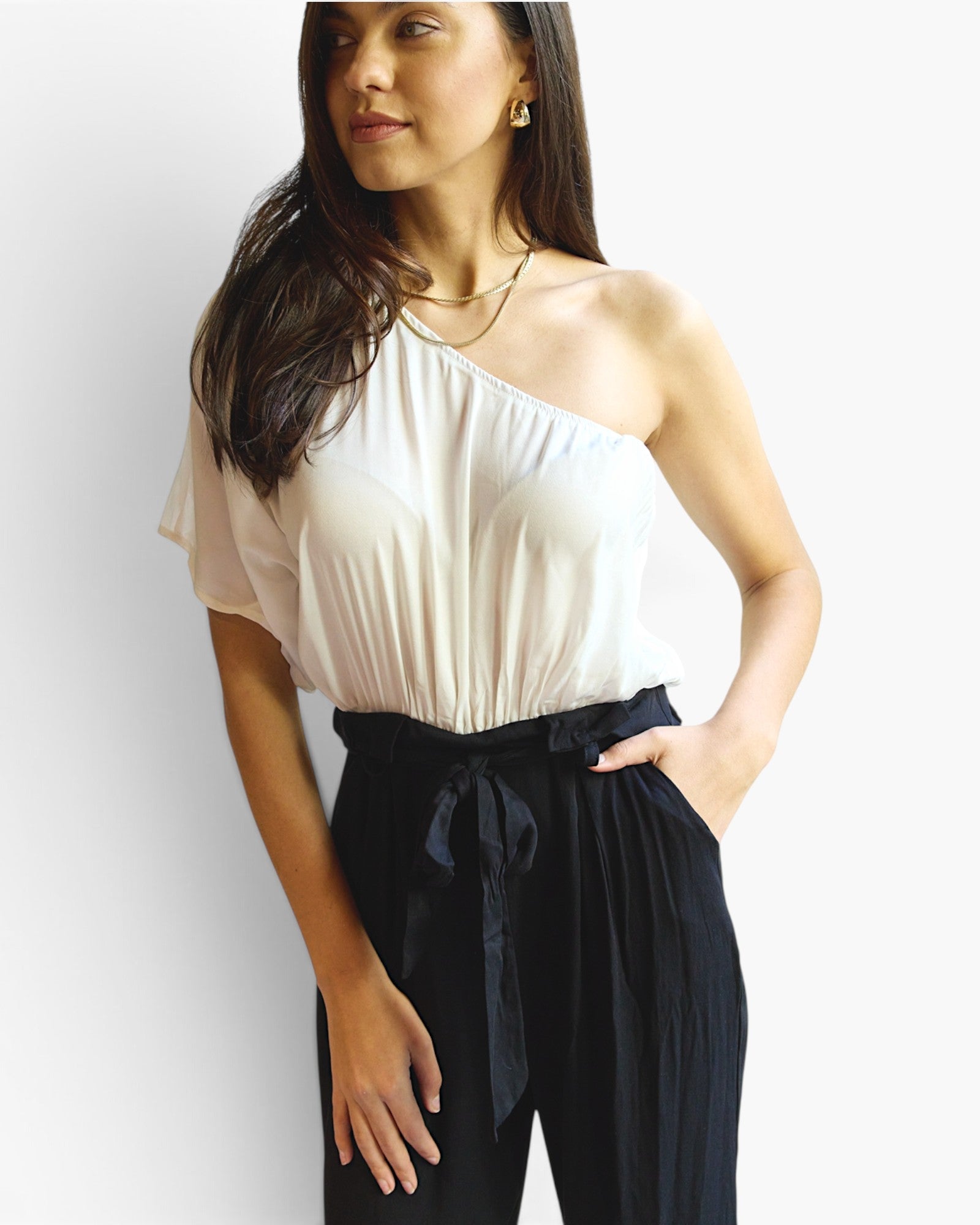 Beach Rose Co. white and black one-shoulder jumpsuit with a paperbag waist, tie belt, and wide-leg silhouette.