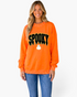 Beach Rose Co. orange sweatshirt with a textured SPOOKY graphic, ghost accent, and white polka-dot trim on a model.