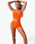 Beach Rose Co. bright orange two-piece bikini with a notched neckline top and high-waisted pleated bottoms on a model