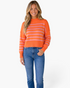 Beach Rose Co. orange and pink striped mock-neck sweater with dropped shoulders worn by a smiling blonde model.