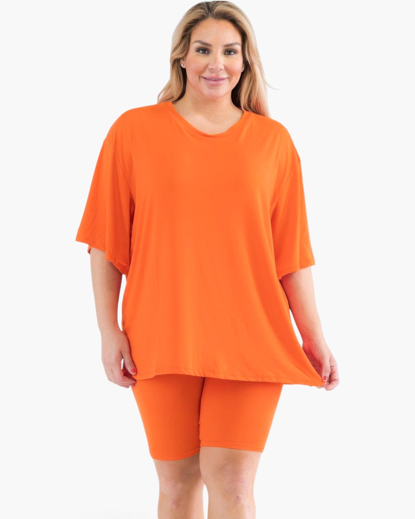 Beach Rose Co. plus size orange loose fit top and matching biker shorts set on a model against a white background