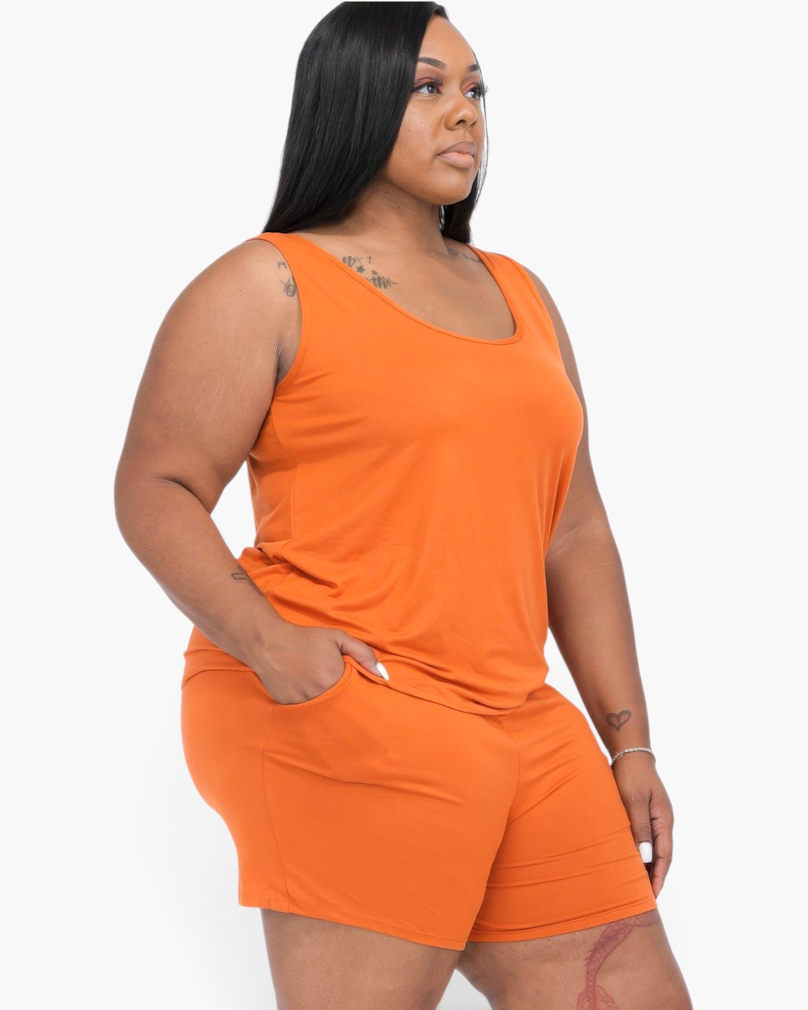 Beach Rose Co. plus size model wearing a vibrant orange stretchy jersey tank top and matching shorts set