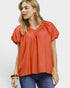 Beach Rose Co. orange puff sleeve blouse with gathered V-neckline and textured fabric. Relaxed fit, lightweight, and breathable.